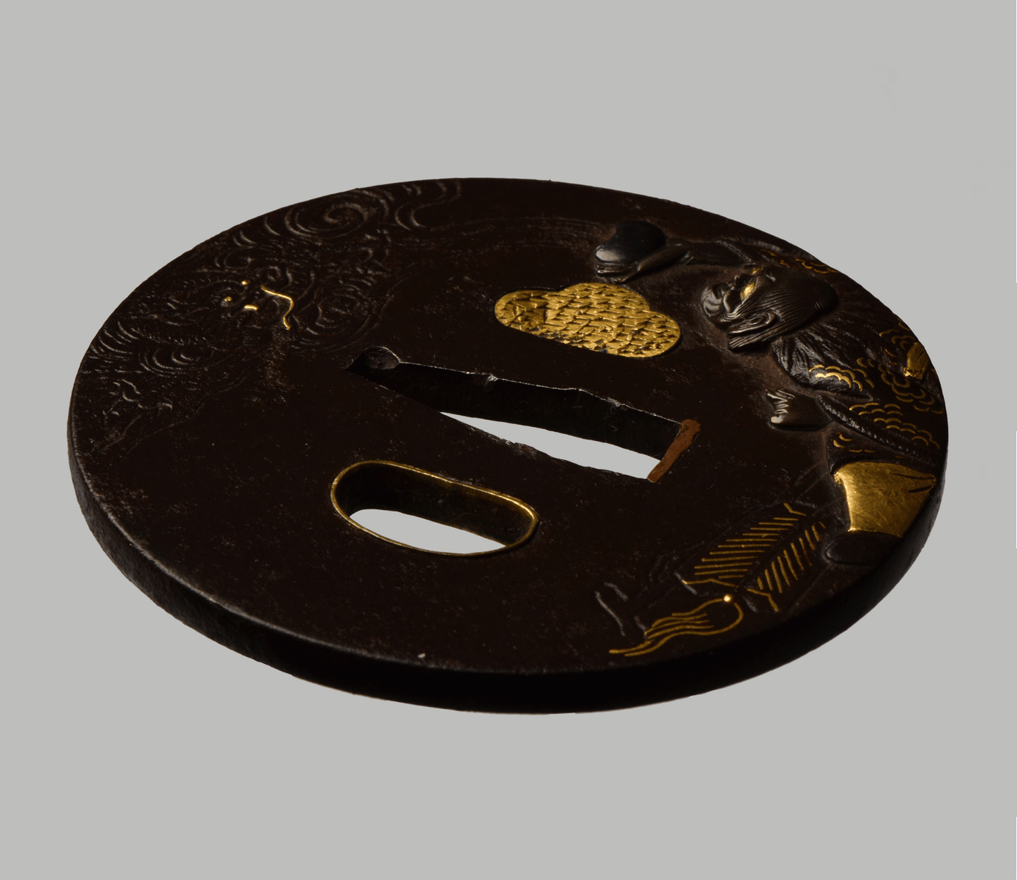Tsuba - Mito - (馬師皇) - Hotei with dragon - shakudo, gold and silver